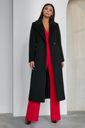 Black wool coat Amber for women – long classic winter coat with lapel collar, belt at the waist, side pockets and back vent. Elegant timeless design, insulated and lined, ideal for cold weather. Model is wearing size 34. Juodas vilnonis paltas Amber – klasikinis ilgas paltas su diržu, šoninėmis kišenėmis ir skeltuku nugaroje.