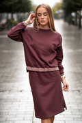 Moteriškas trikotažinis kostiumėlis: nuleistų pečių džemperis–palaidinė su kišenėmis ir tiesus sijonas su dviem skeltukais, elastingu juosmeniu; minkštas kvėpuojantis audinys, dydžiai 36–52, siūta Lietuvoje. / Women’s knit two-piece set with dropped-shoulder top and straight skirt with side slits, elastic waist; breathable cotton-rich fabric, sizes 36–52, made in Lithuania