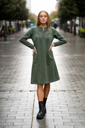 Green cotton-elastane midi dress for women with handmade dragonfly embroidery, bell silhouette and side pockets, designed and made in Lithuania. Comfortable and elegant knitwear dress perfect for autumn and winter season. Žalia trikotažinė suknelė moterims su rankų darbo laumžirgio siuviniu, varpelio siluetu ir kišenėmis – pagaminta Lietuvoje
